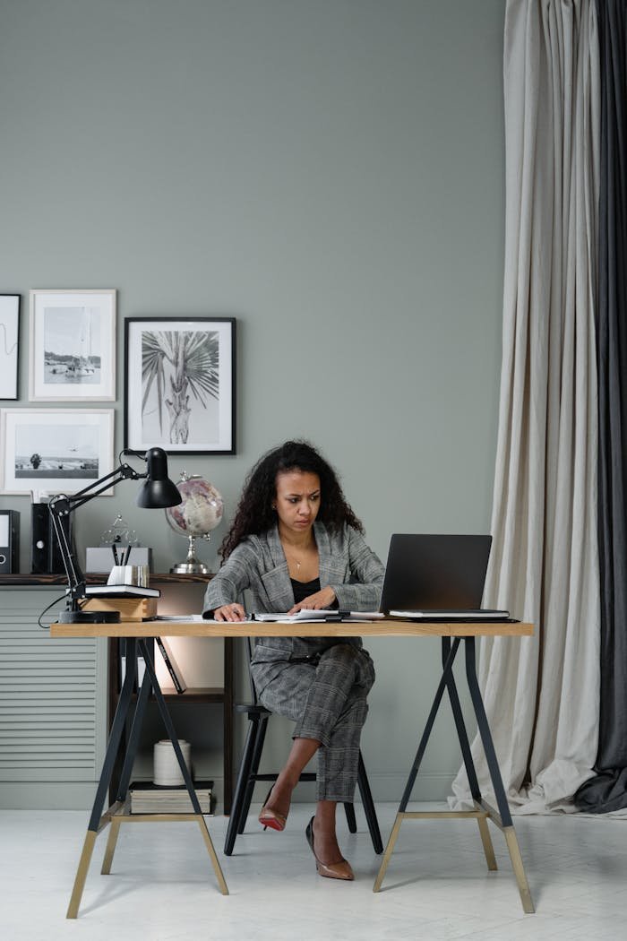 Focused professional woman working at desk in modern office setting.